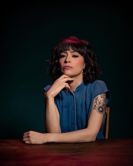 Melissa Villaseñor in a blue shirt poses for a photoshoot.